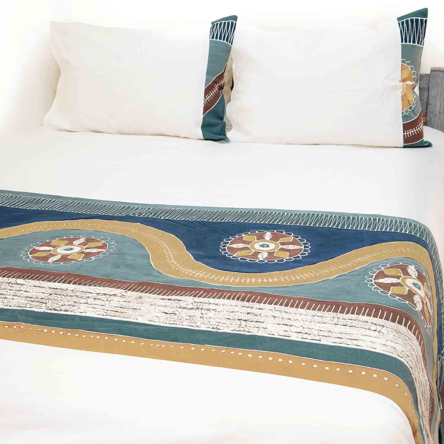 A blue and natural coloured hand painted duvet set, inspired by Mali's landscapes, with rolling patterns across the duvet.