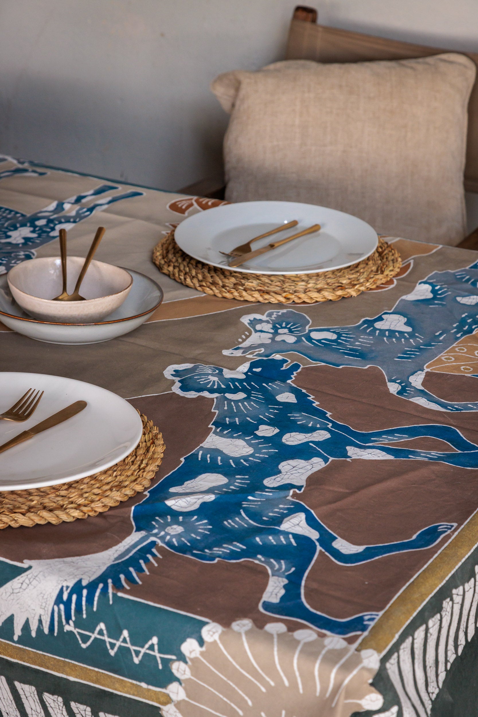 Table setting with a decorative tablecloth featuring wild dogs, in support of zambian carnivore programme