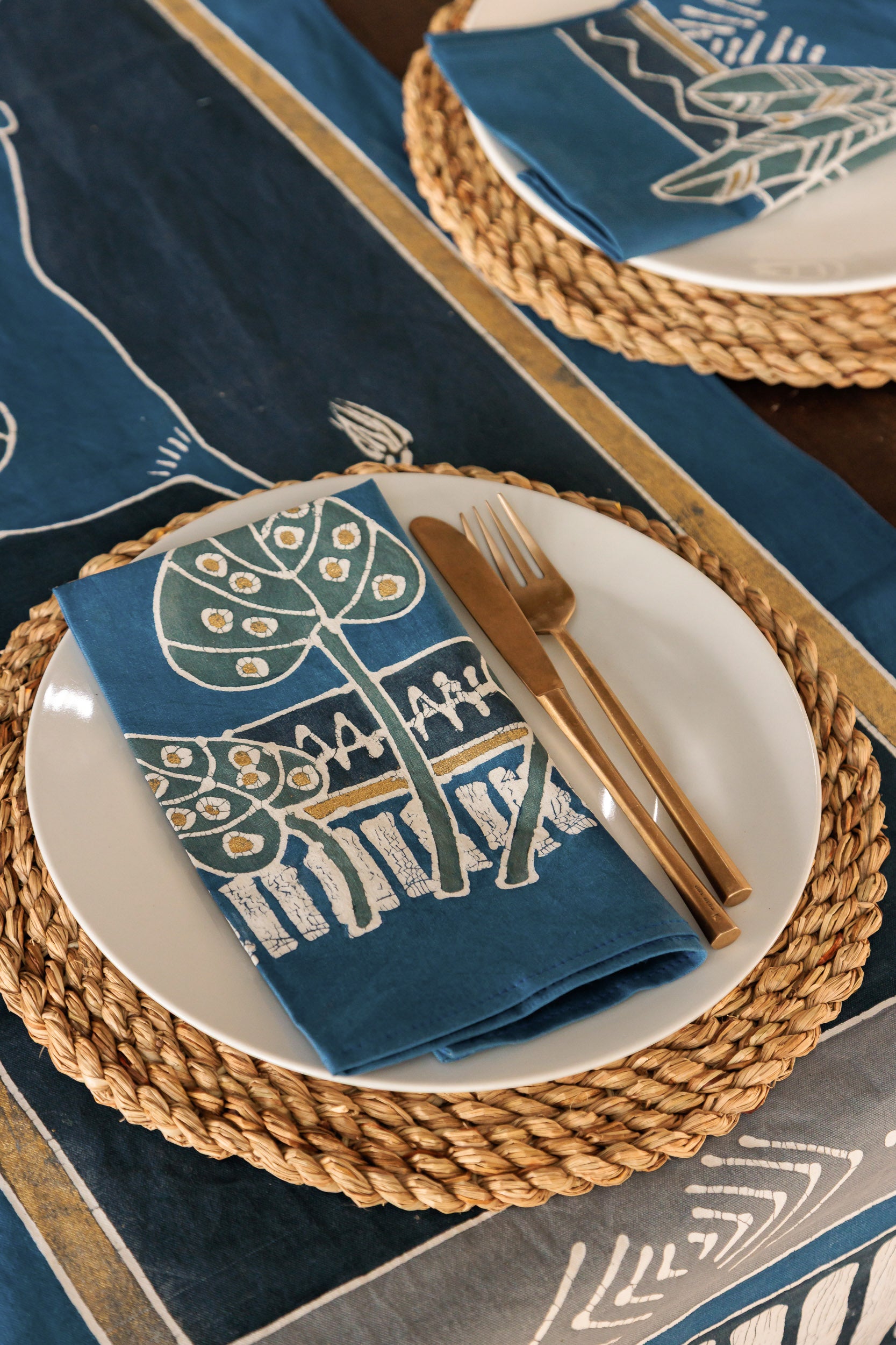 Table setting with blue floral design napkins.