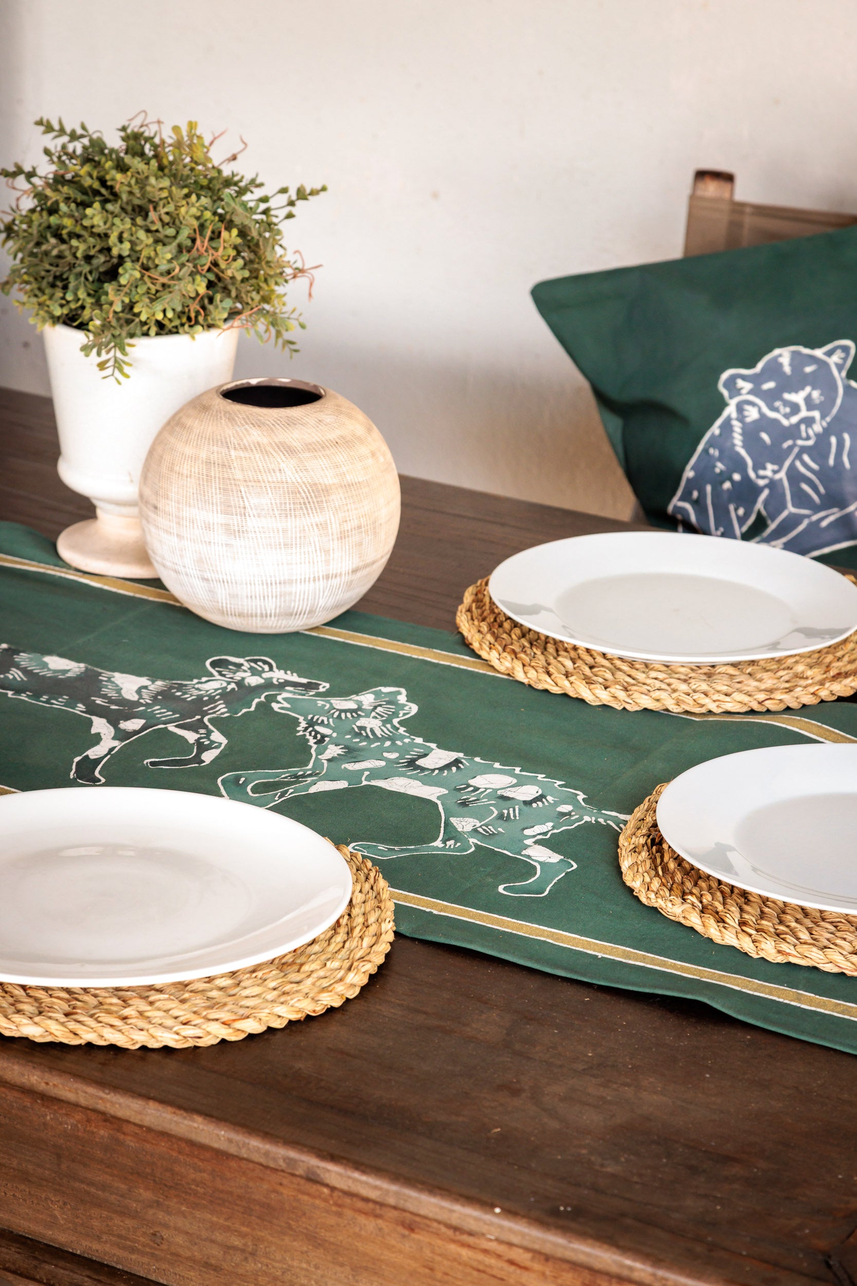 Green table runner featuring wild dogs, handpainted batik, textiles in support of carnivore animal conservation