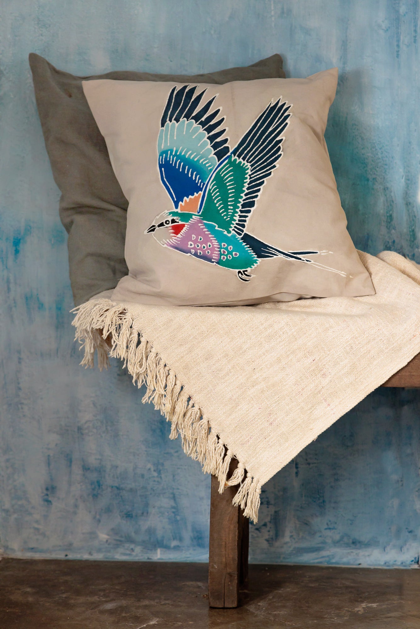 Hand painted beige cushion cover with a colourful African bird, the lilac breasted roller.