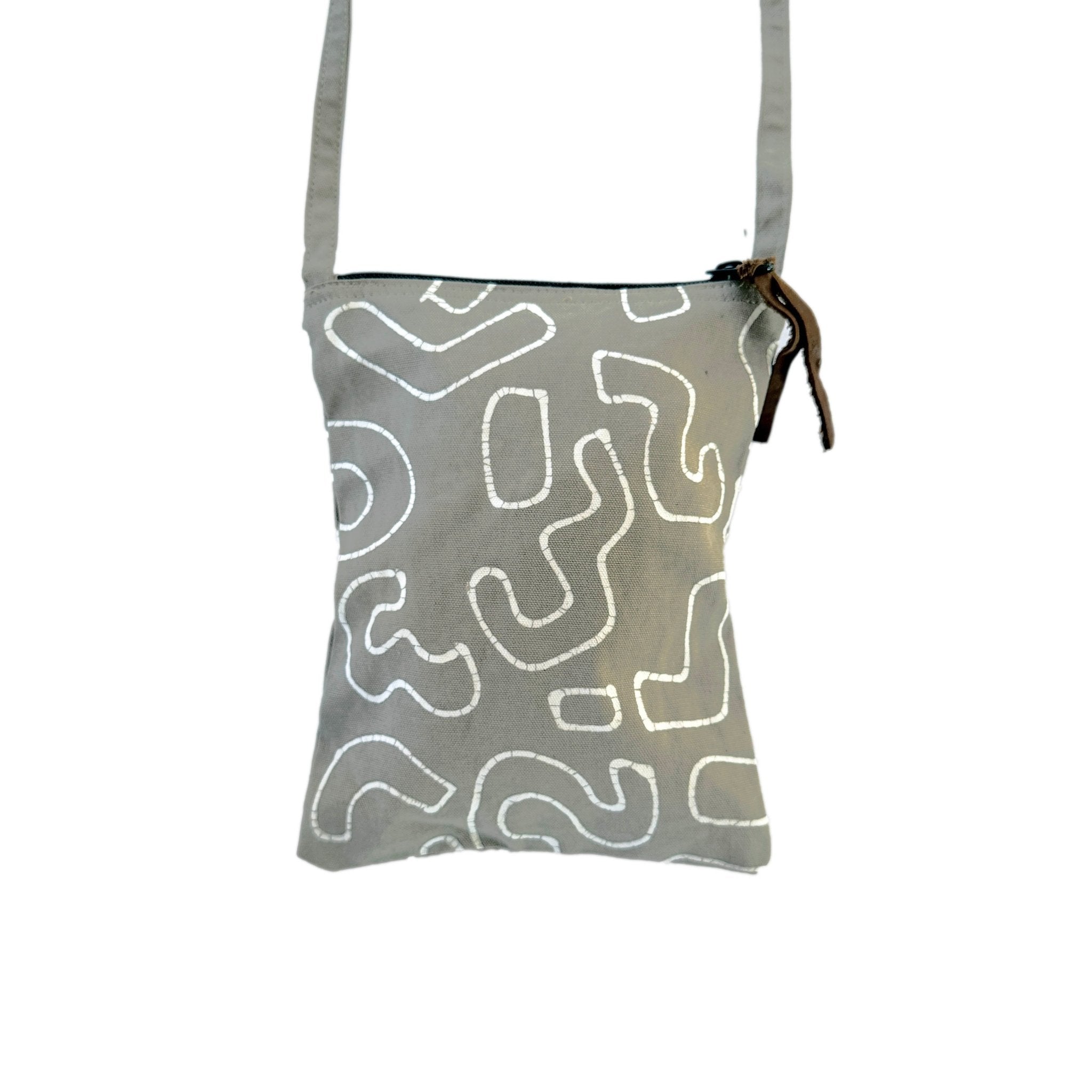 African made light taupe passport bag, adorned in white swirls and made to travel sustainably.