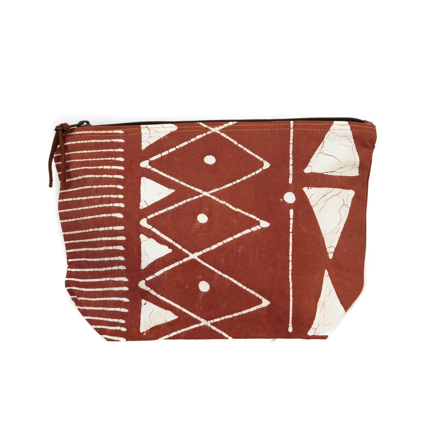 The perfect sustainable travel wash bag, in a rust red adorned with detailed white geometric patterns.
