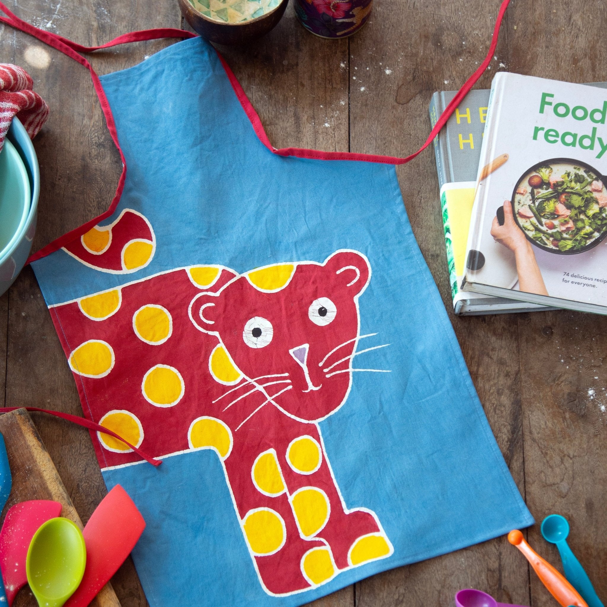 Hand-painted children's leopard apron, with bright vibrant reds and blues.