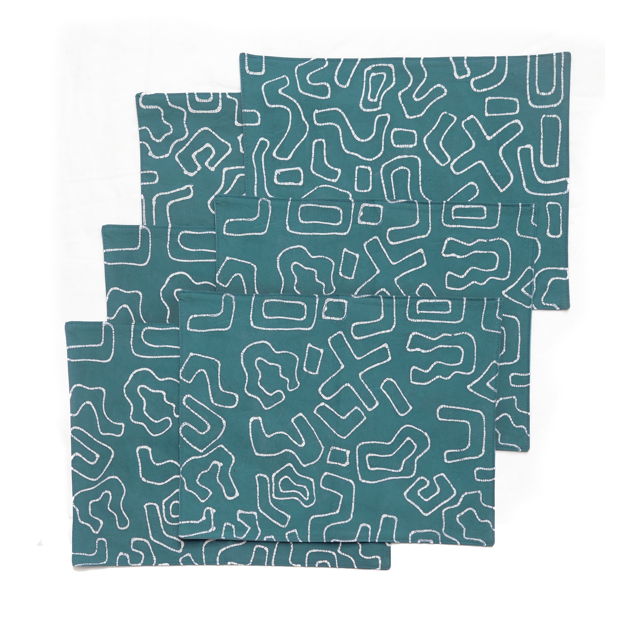 Teal placemats with bold graphic african inspired patterns drawn in batik