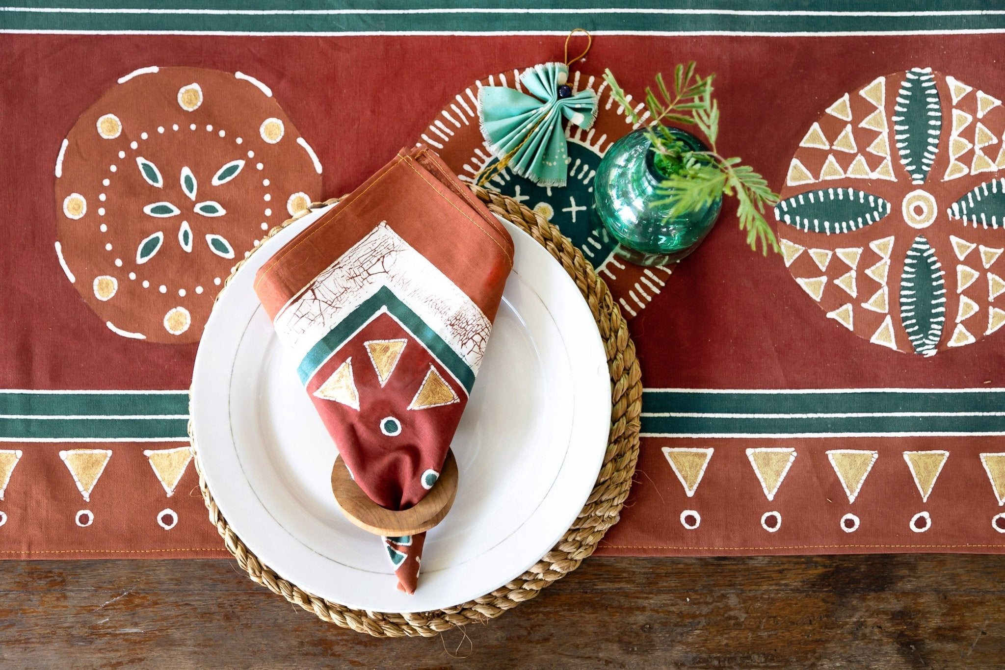 Elevate your dining room table witth our bold red and gold napkins, adorned with intricate circular patterns.