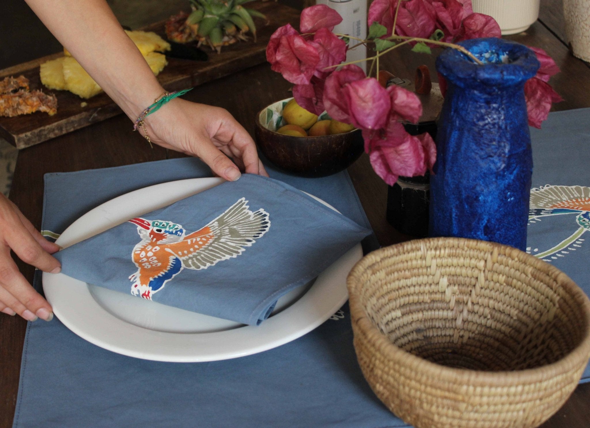 African made Kingfisher napkins on a blue/grey background destined to bring joy and sustainability to your dining table.