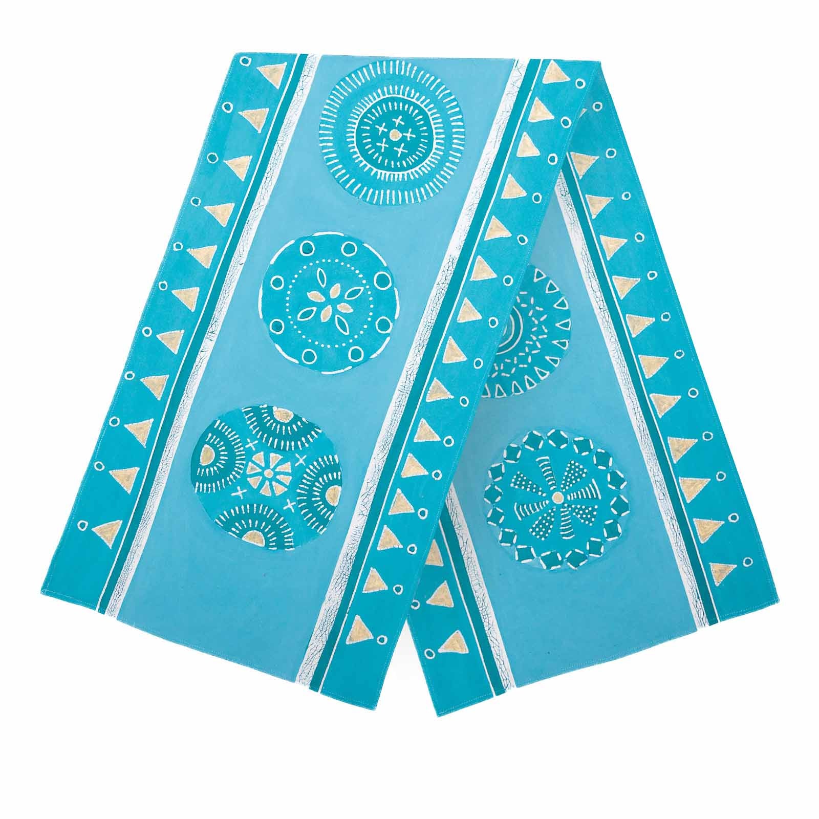 The perfect light blue table runner with circular patterns and gold accents.