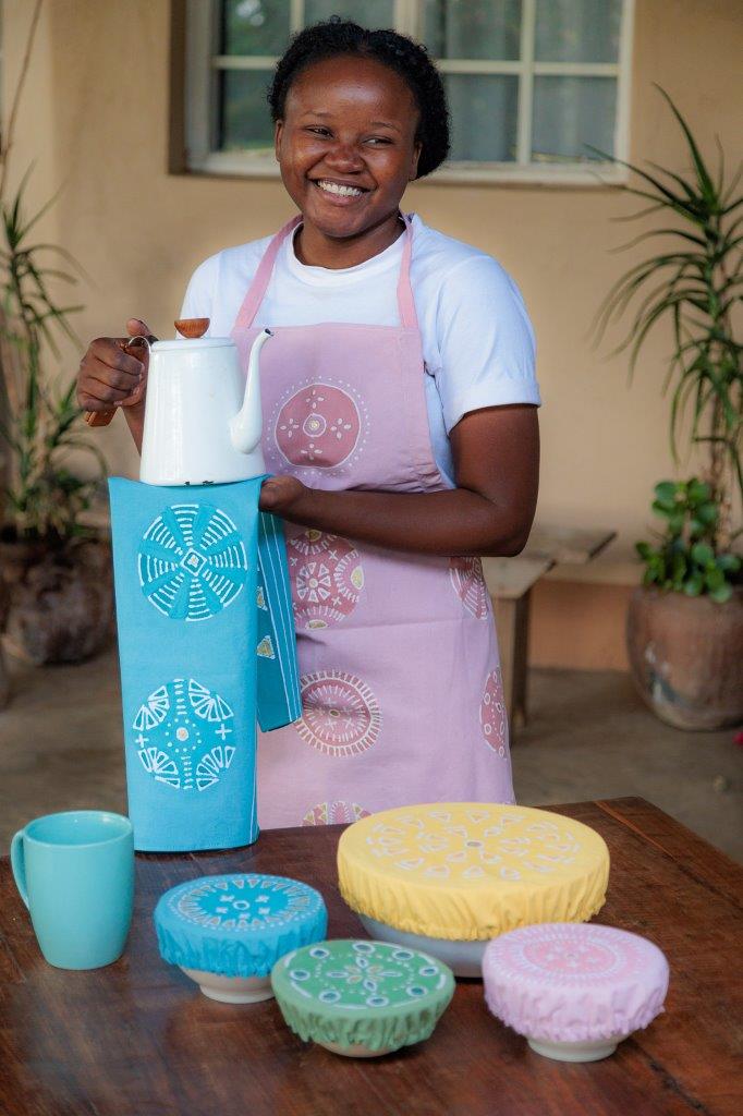 African made and hand-painted light blue tea towel, adorned with intricate circular patterns and gold accents.