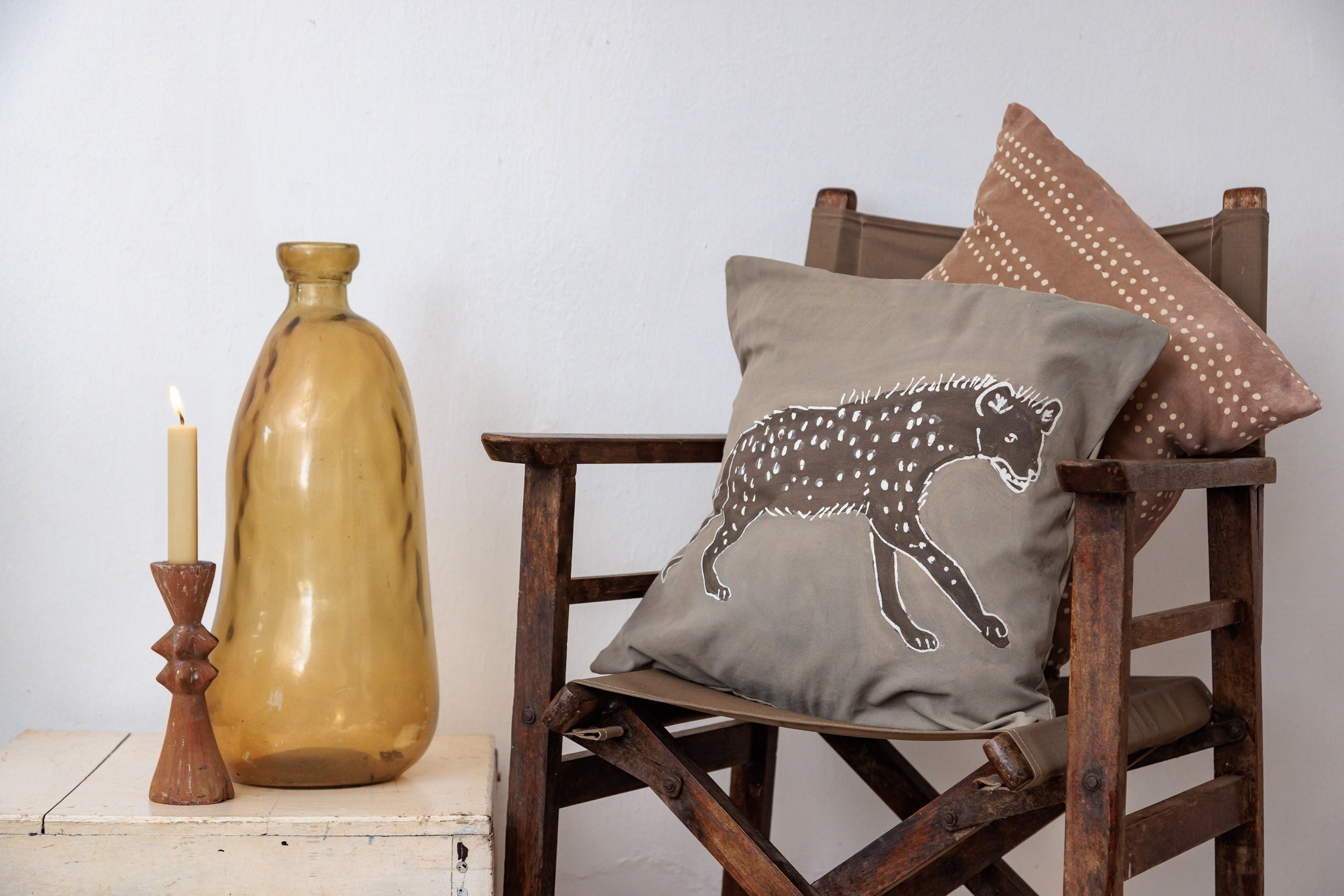 Decorative pillow with a soft beige hyena design, hand painted on batik