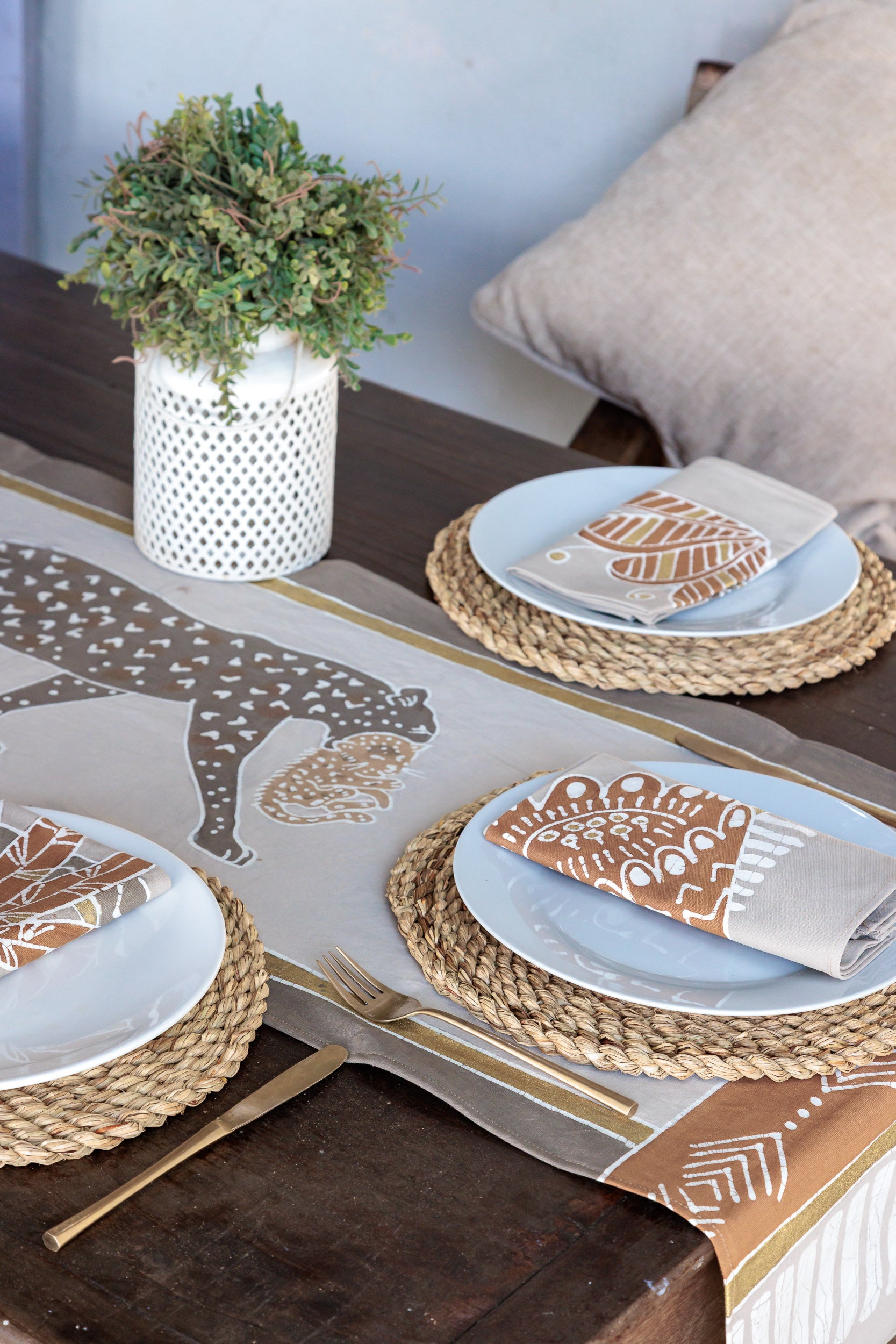 Beige table runner featuring leopard carrying cub, with matching napkins. Handcrafted batik textiles from Africa