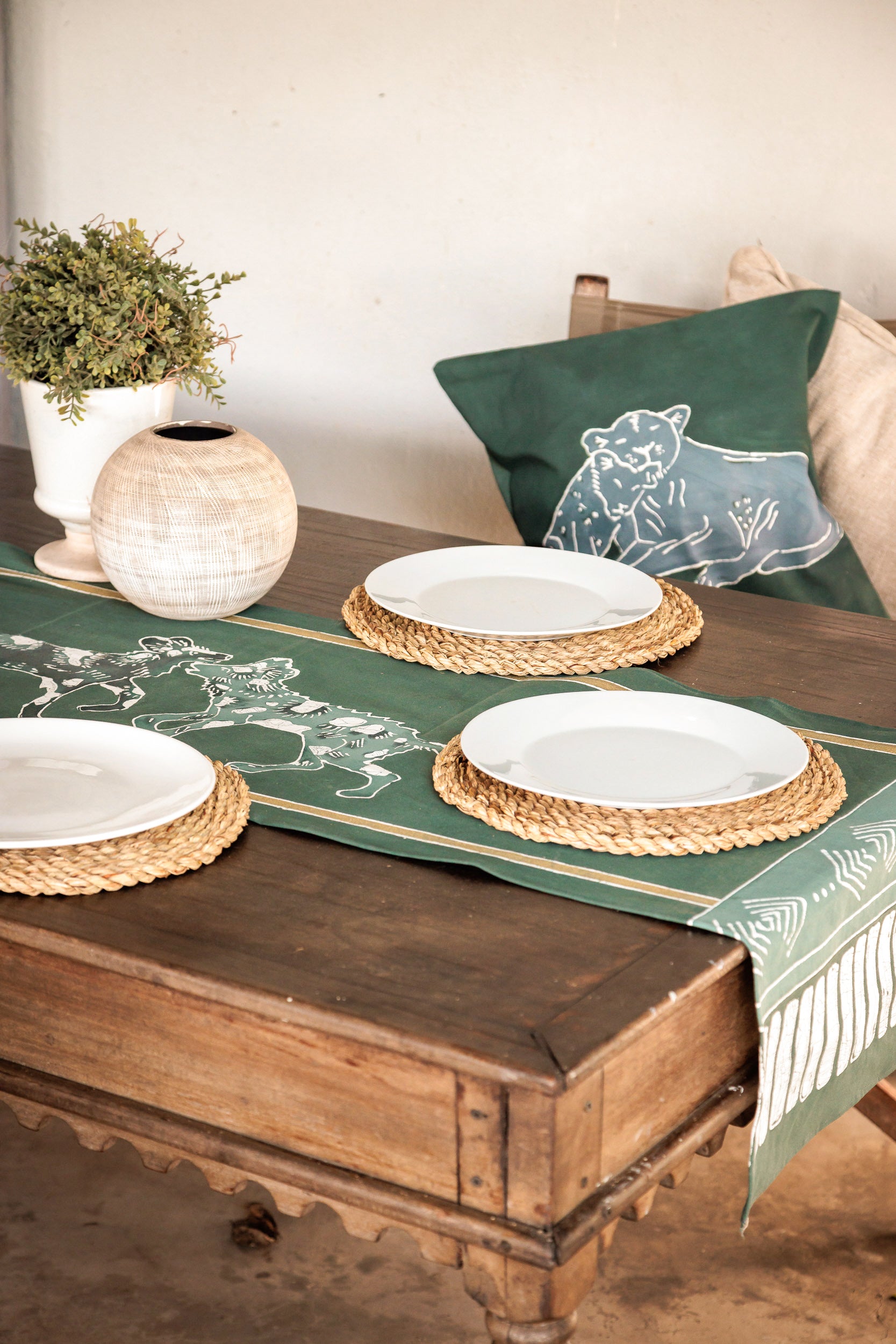 Table setting with a green table runner featuring wild dogs 