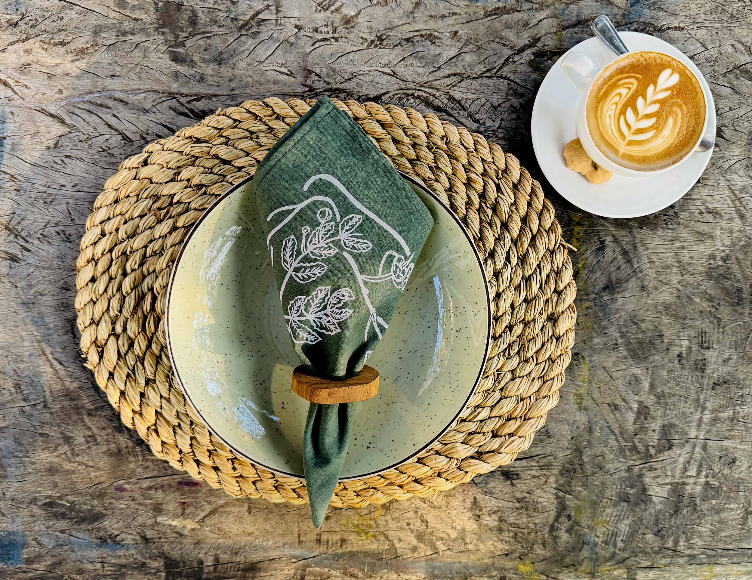 Forest green cotton napkin with subtle hand-printed leaf design, ethically handcrafted in Zambia for sustainable, eco-friendly dining table decor and artisan interiors.
