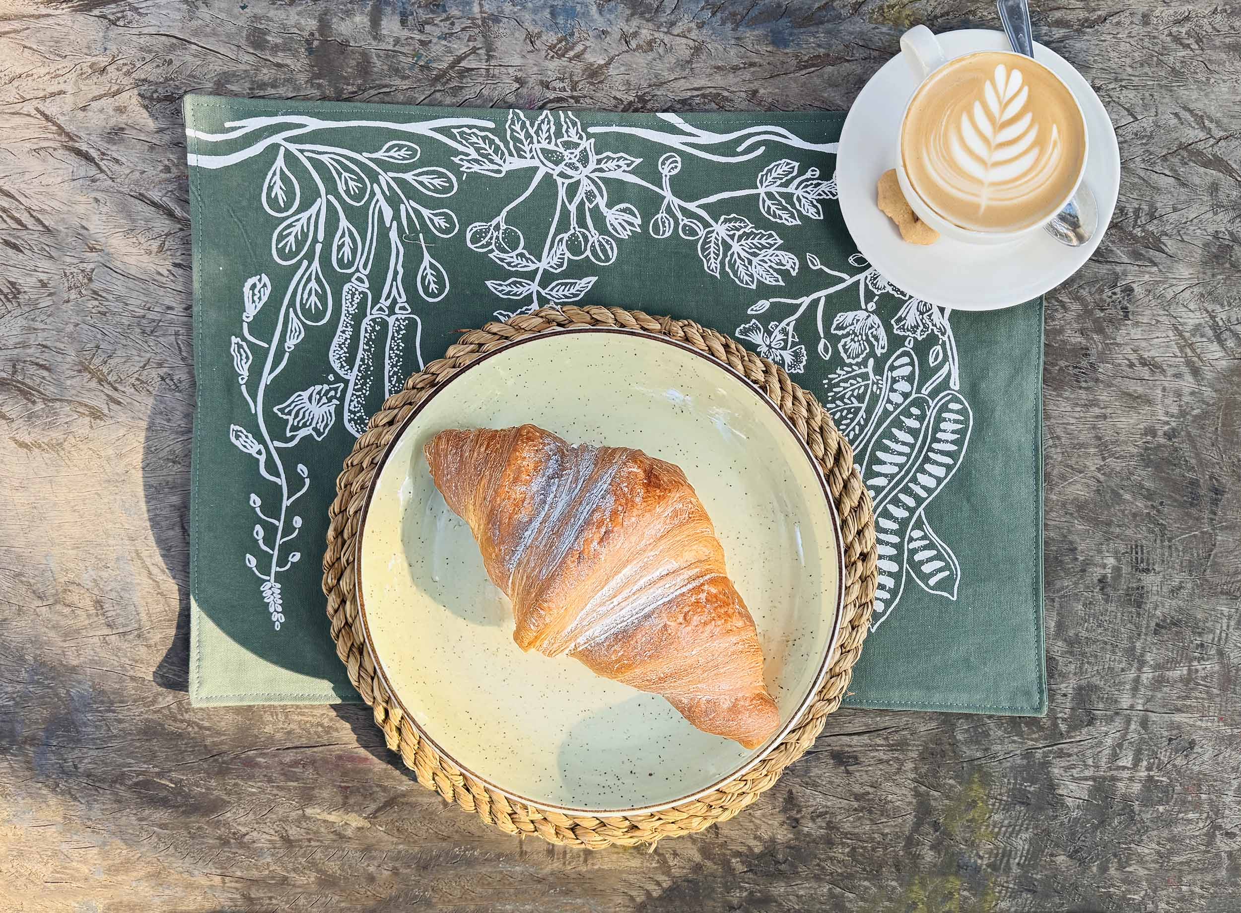 Set of forest green cotton table mats with subtle layered leaf prints, ethically handcrafted in Zambia for sustainable, eco-friendly dining room decor and artisan home interiors.
