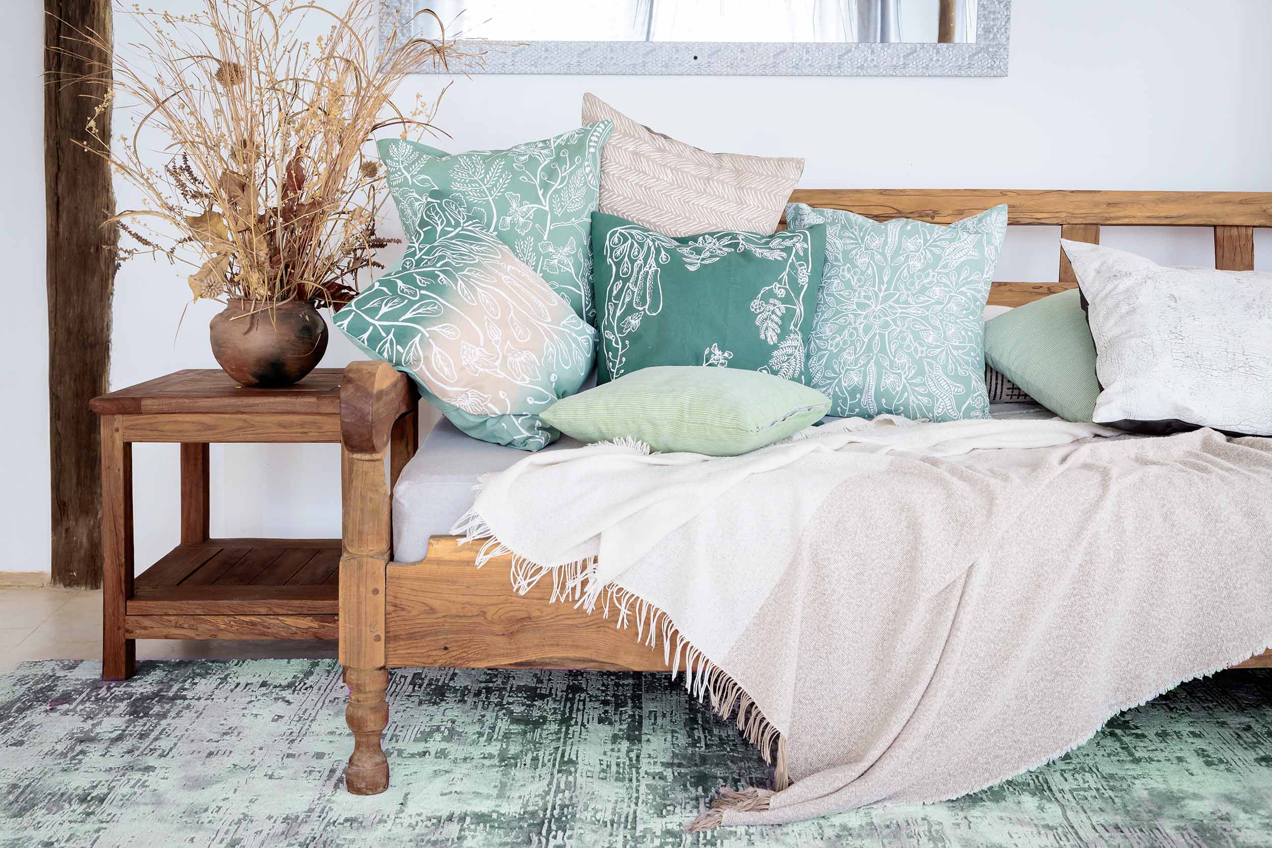 A selection of green cotton throw pillows with hand-printed leaf designs, ethically handcrafted in Zambia to enhance sustainable and eco-friendly living room or bedroom decor with artisan charm.
