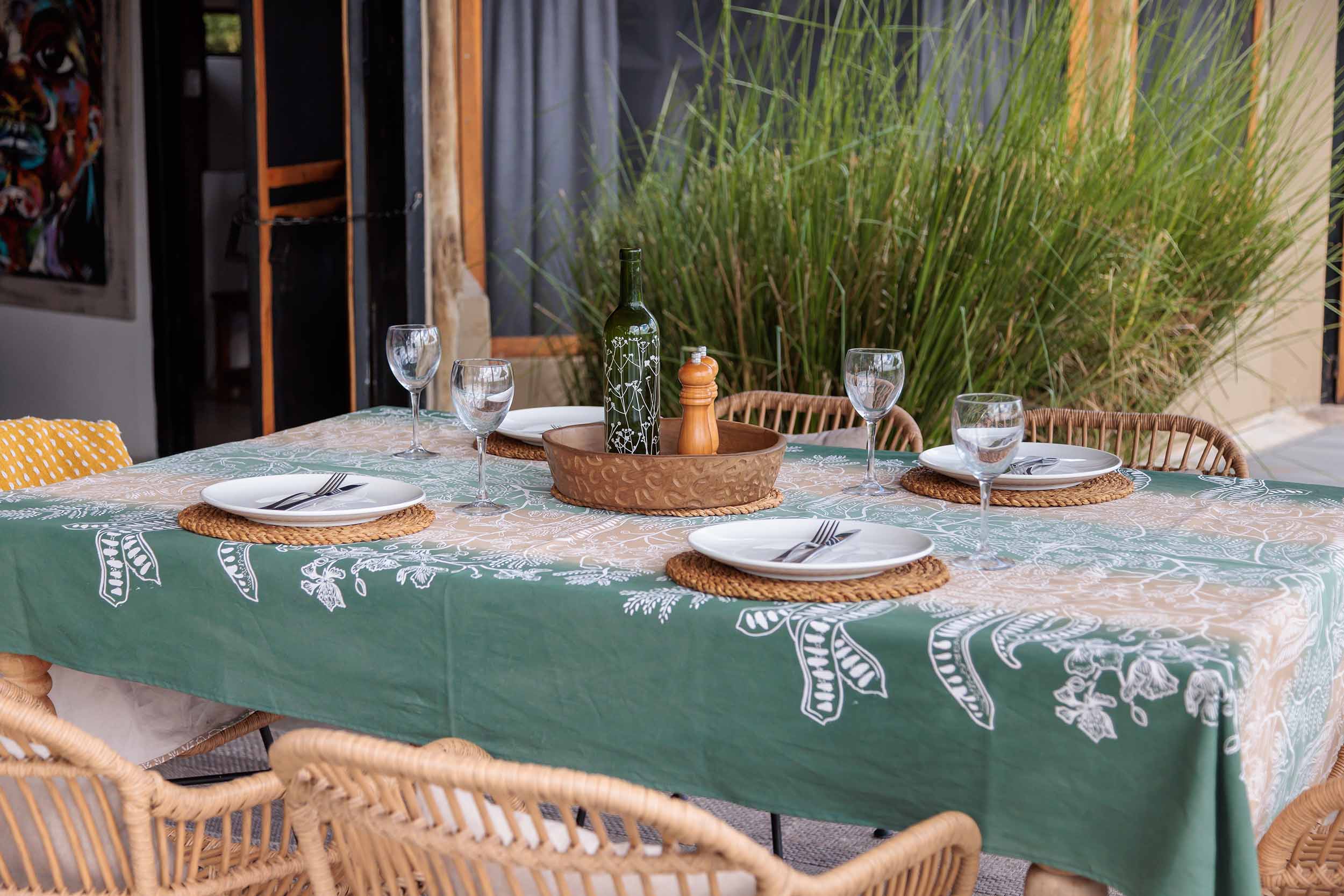 Cotton tablecloth featuring a bold hand-printed floral tree design in earthy tones, ethically handcrafted in Zambia for sustainable, eco-friendly dining room decor and artisan table settings.

