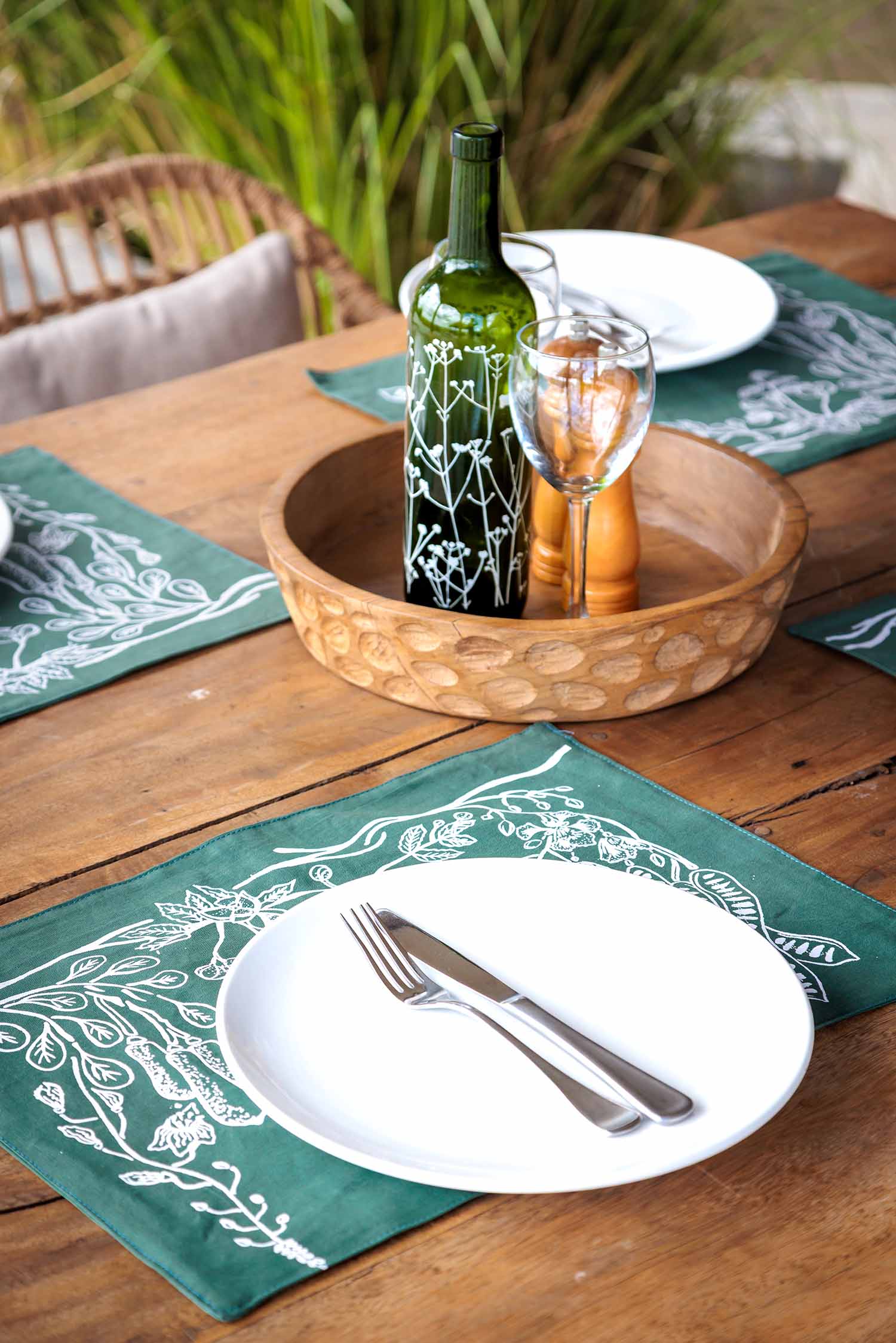Set of dark green cotton table mats with subtle leaf patterns, ethically handcrafted in Zambia for sustainable, eco-friendly dining room decor and artisan home interiors.
