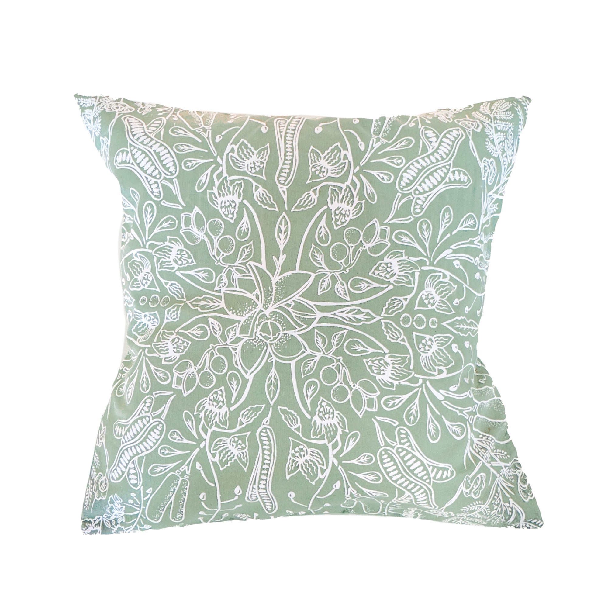 Green cotton cushion cover featuring a symmetrical hand-printed leaf design, styled on a neutral surface, ethically handcrafted in Zambia for sustainable, eco-friendly living room or bedroom decor and artisan interiors.
