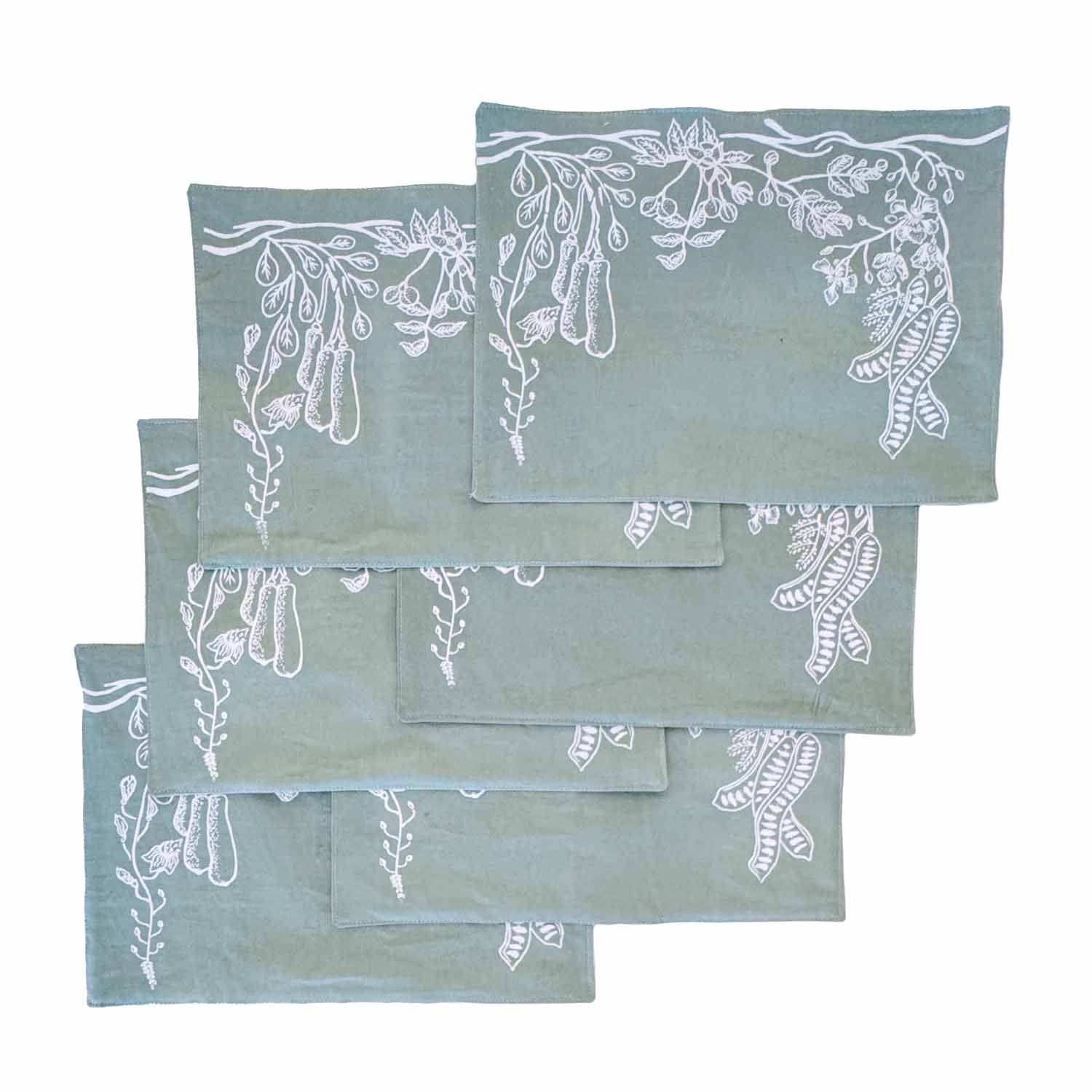 Set of sage green cotton table mats with hand-printed leaf patterns, ethically handcrafted in Zambia for sustainable, eco-friendly dining room decor and artisan home interiors.
